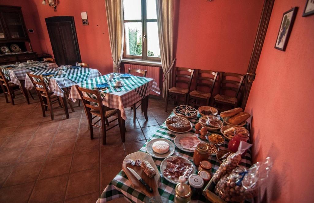 jadalnia ze stołami z talerzami żywności w obiekcie Agriturismo Al Brich Quadriple room with breakfast w mieście Albaretto Della Torre 