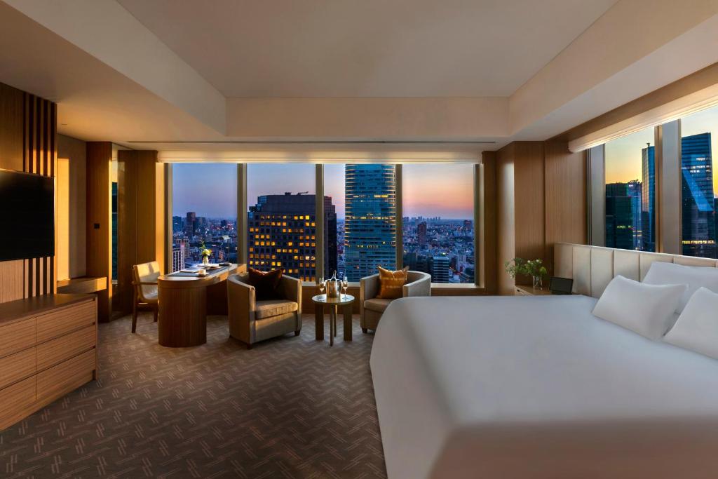 a hotel room with a bed and a view of a city at The Okura Tokyo in Tokyo