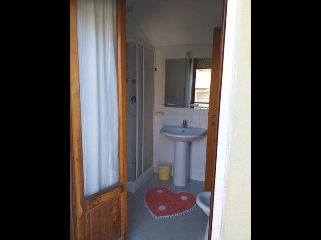 łazienka z umywalką, toaletą i lustrem w obiekcie Room in BB - Spacious triple room a stones throw from the sea w mieście Pineto