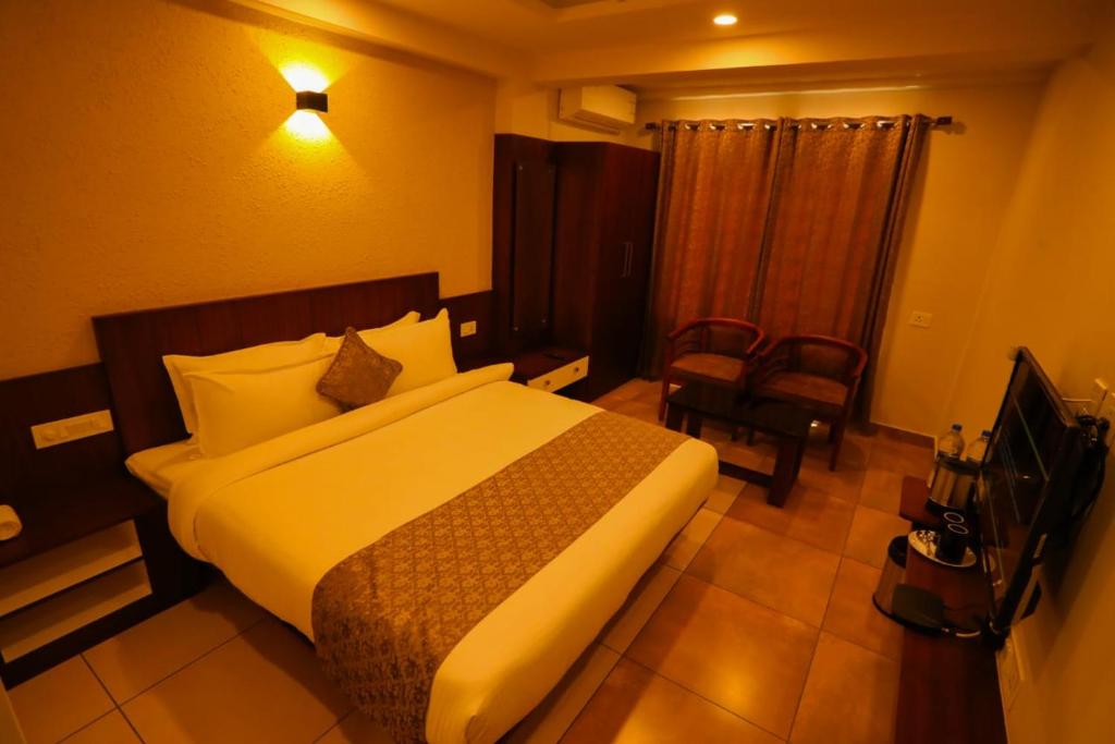 a hotel room with a bed and a chair at Zubis Inn Hotel in Kalpetta