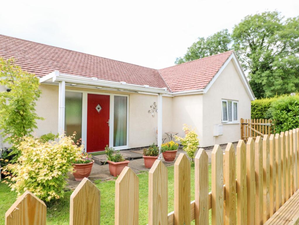 a house with a fence in front of it at Clovermead Cottage in Willington