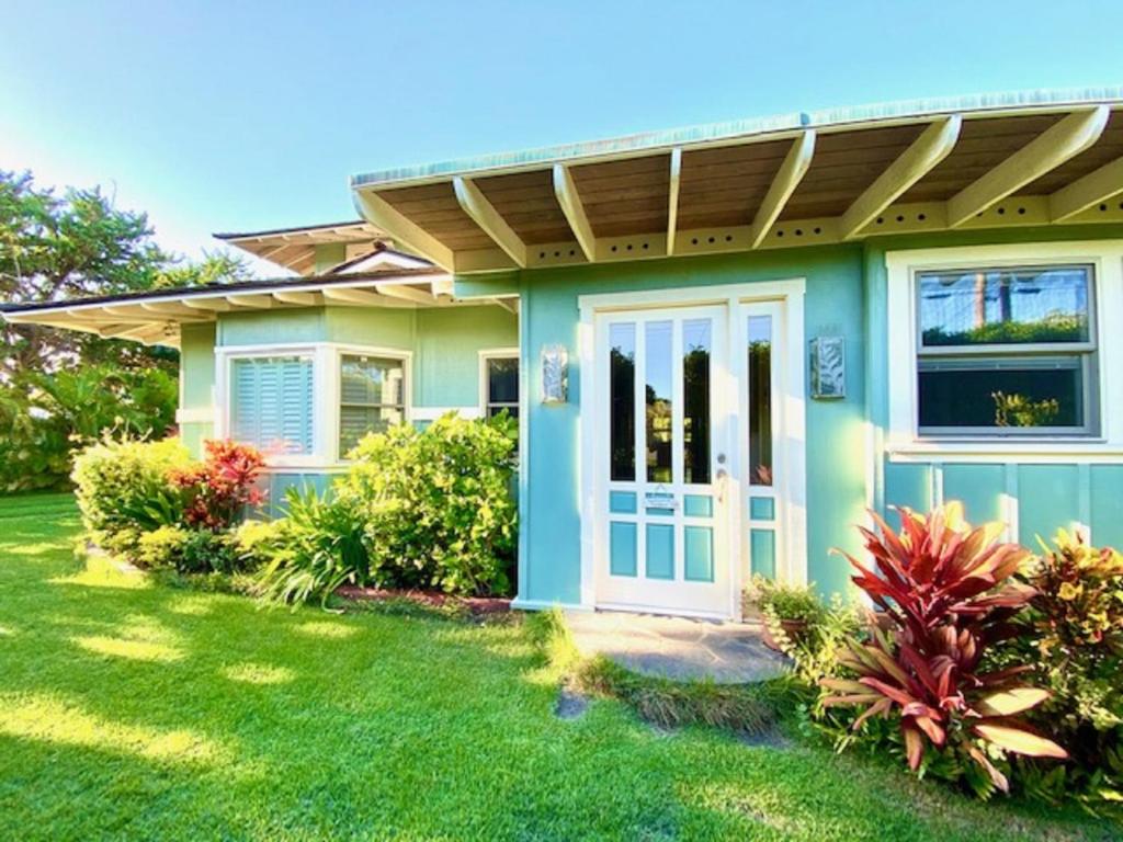 a green house with a blue door and a yard at Modern Luxury Beach House Kailua in Kailua