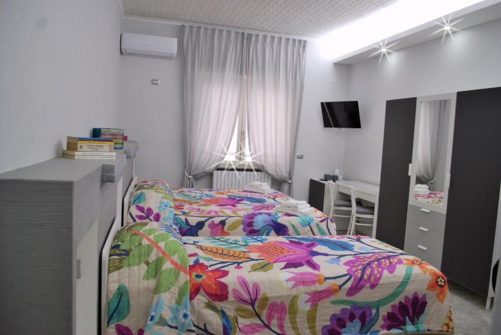 a bedroom with a bed with a colorful comforter at Casa Torrese in Torre del Greco