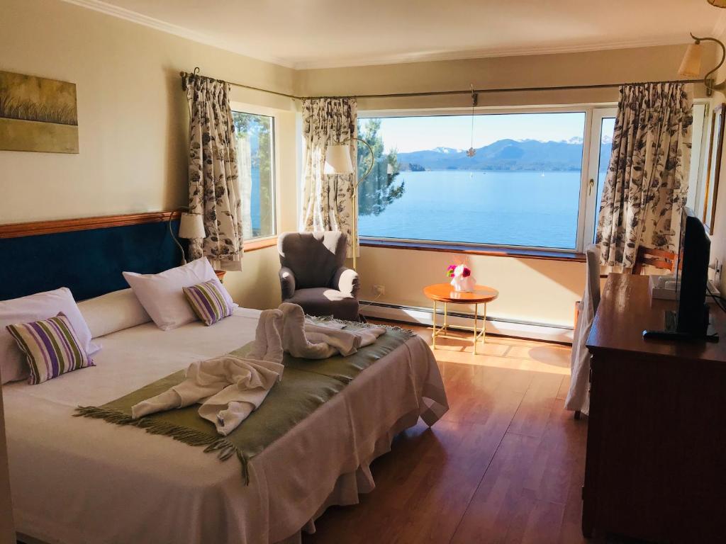 a bedroom with a bed and a large window at Sol del Nahuel - Hotel & Spa in San Carlos de Bariloche