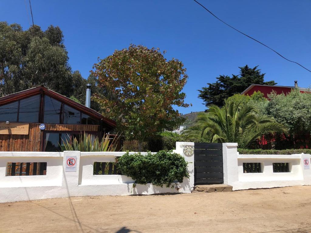 a white fence in front of a house at Hostería Zapallar in Zapallar