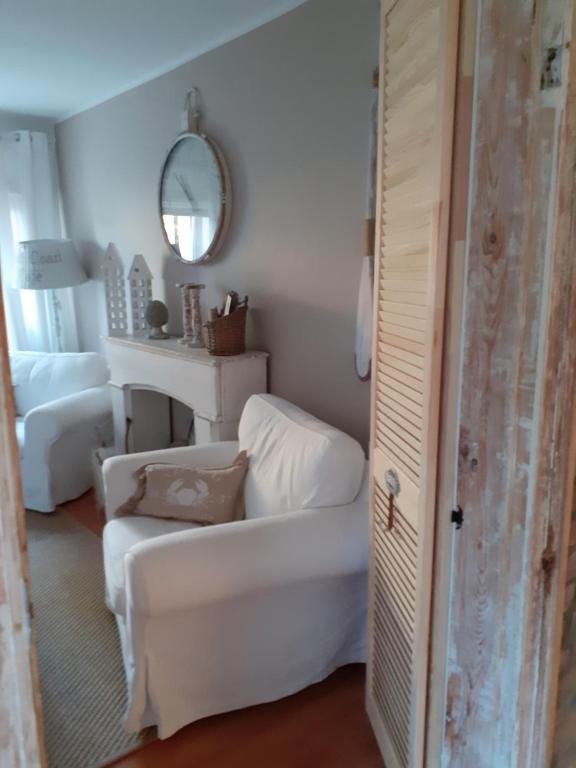 a living room with a white couch and a mirror at Beach House Old in Międzyzdroje