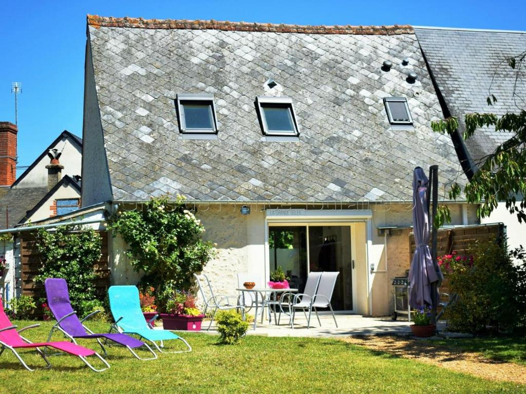 a group of chairs and a table in front of a house at Gîte Veigné, 3 pièces, 4 personnes - FR-1-381-102 in Veigné