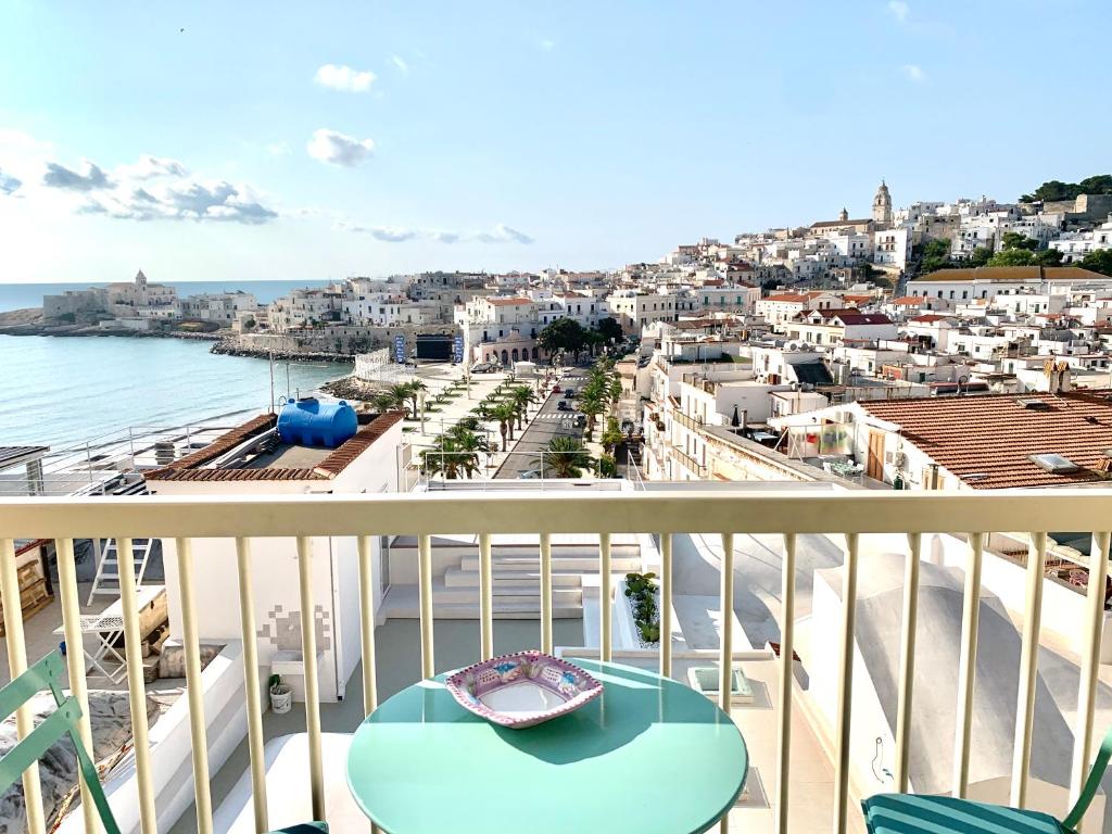 a balcony with a table and a view of a city at Opera Dimore in Vieste