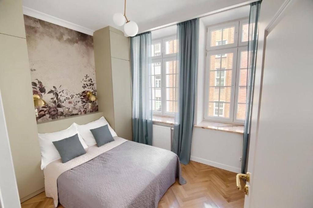 1 dormitorio con 1 cama y 2 ventanas en Apartament Attyka Old Town Gdańsk en Gdansk