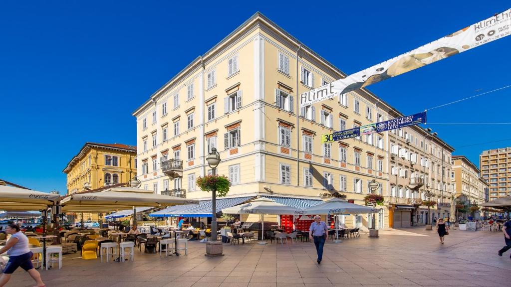 a large white building on a street with people walking at Main Square - Lloyd apartment in Rijeka