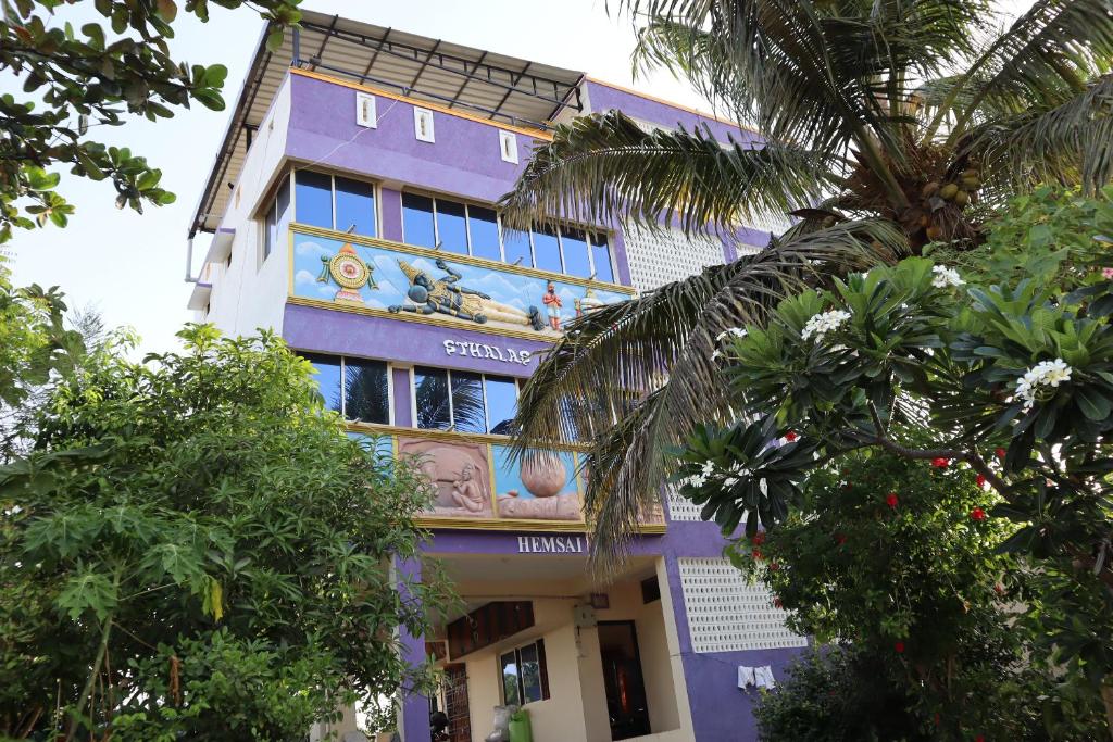 馬哈巴利普拉姆的住宿－STHALAS，一座紫色的建筑,旁边有一幅画