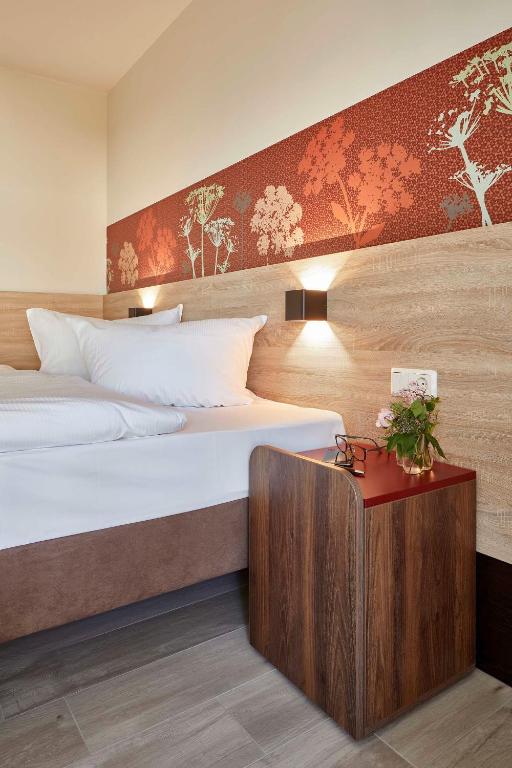 a bedroom with two beds and a table with flowers at Feriendorf Rerik in Rerik