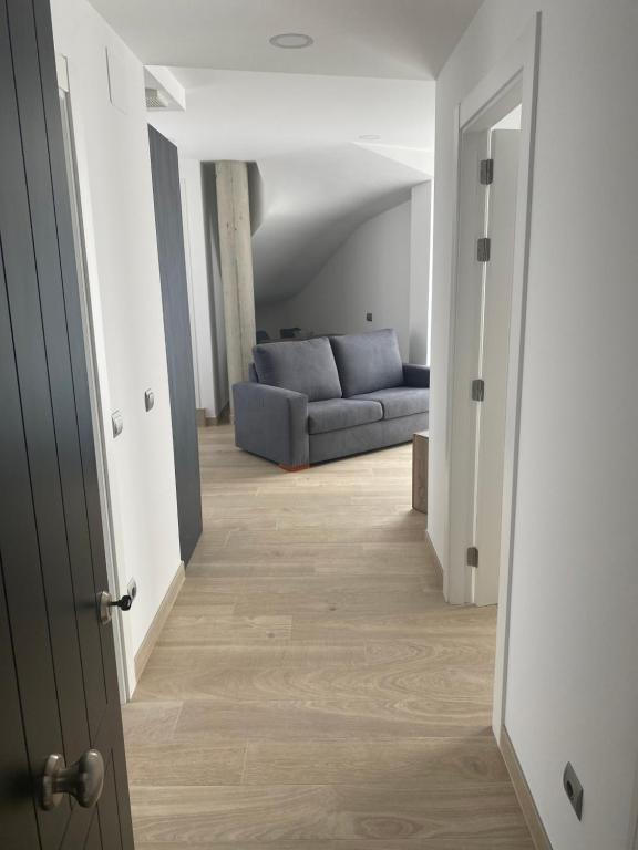 a hallway leading to a living room with a couch at Apartamentos Hostería de Boo in Boó de Piélagos