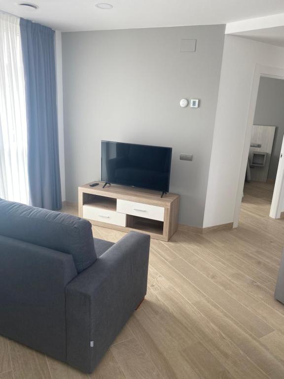 A television and/or entertainment centre at Apartamentos Hostería de Boo