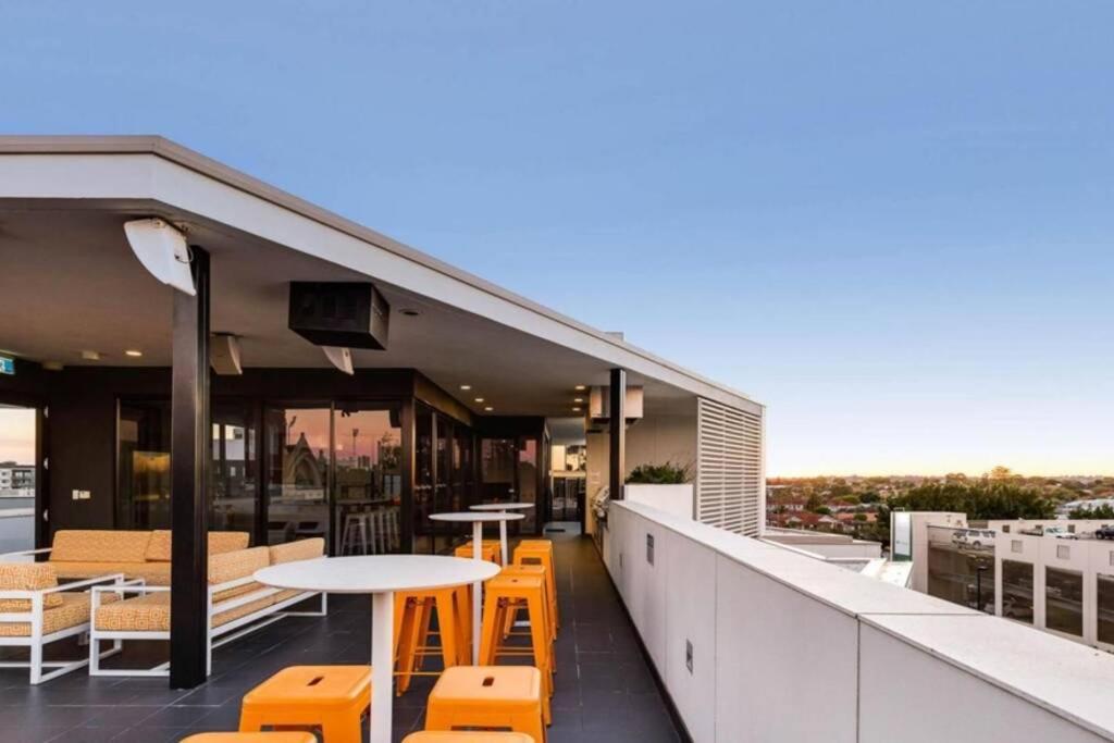 uma varanda com mesas e cadeiras num edifício em Subiaco Rooftop Terrace - EXECUTIVE ESCAPES em Perth
