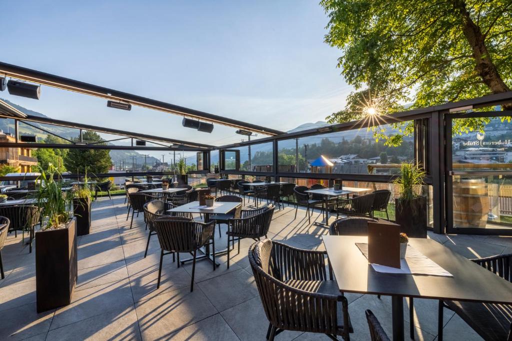 a restaurant with tables and chairs on a balcony at Hotel Hubertus in Sankt Johann im Pongau