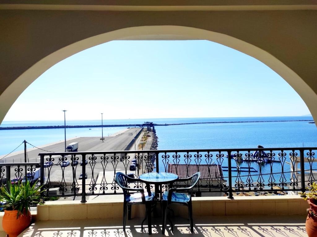 a balcony with a table and chairs and the ocean at Limanaki in Kymi