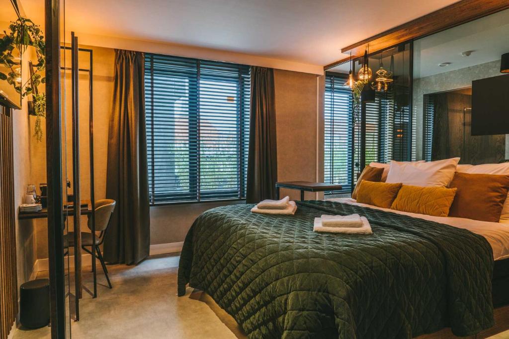 Una habitación de hotel con una cama con dos toallas. en SoHotel, en Schagen