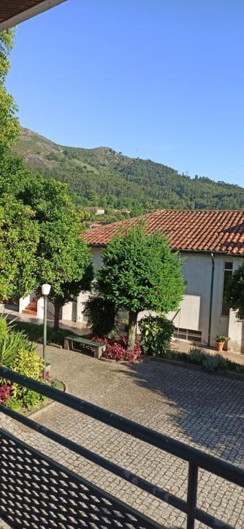 a group of buildings with trees and a fence at Pensão Continental Machado in Caldelas