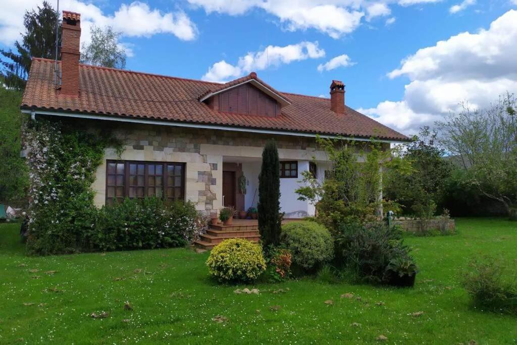 una piccola casa bianca con un cortile verde di Casa Las Lindes Valle de Cabuerniga , Cantabria a Cabuérniga