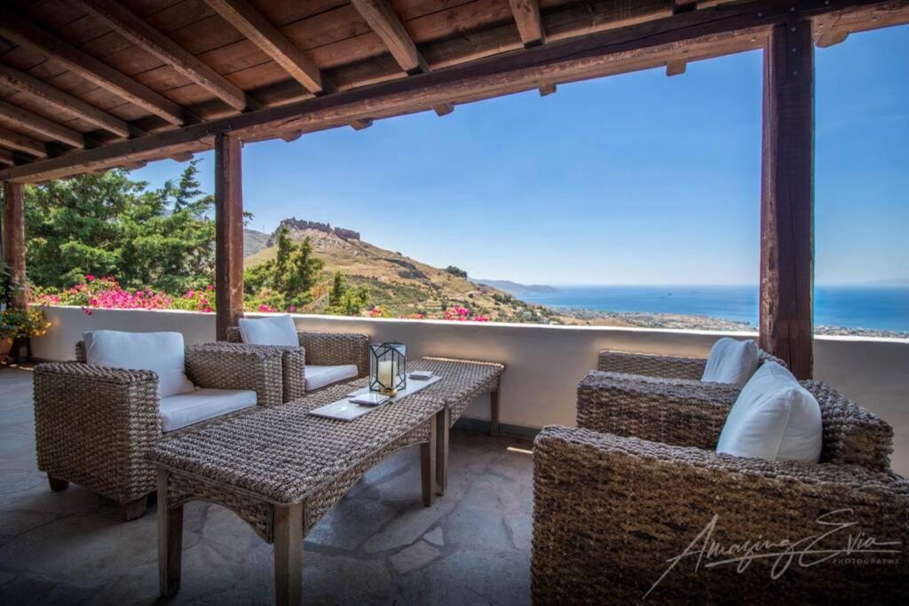 un patio con tavolo e sedie e l'oceano di Villa Kasteli - Secret Beauty in the Mountains a Karistos