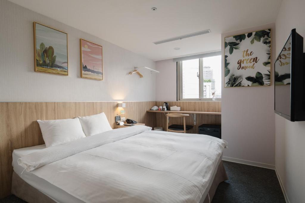 1 dormitorio con 1 cama blanca grande y escritorio en Hotel attic en Taipéi