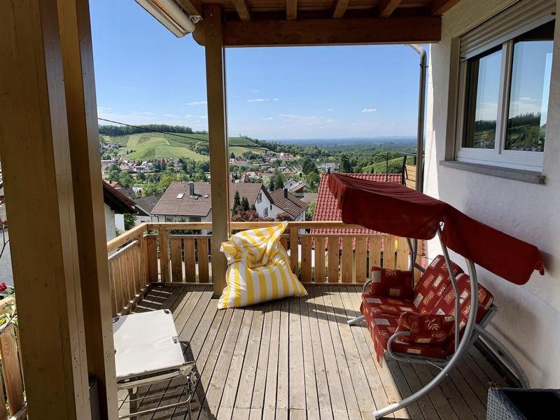 a balcony with chairs and a view of a town at Ferienwohnung JoSi in Kappelrodeck