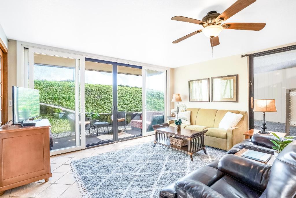 ein Wohnzimmer mit einer Couch und einem Deckenventilator in der Unterkunft Makahuena 4105 Poipu Ocean Breeze in Kipu