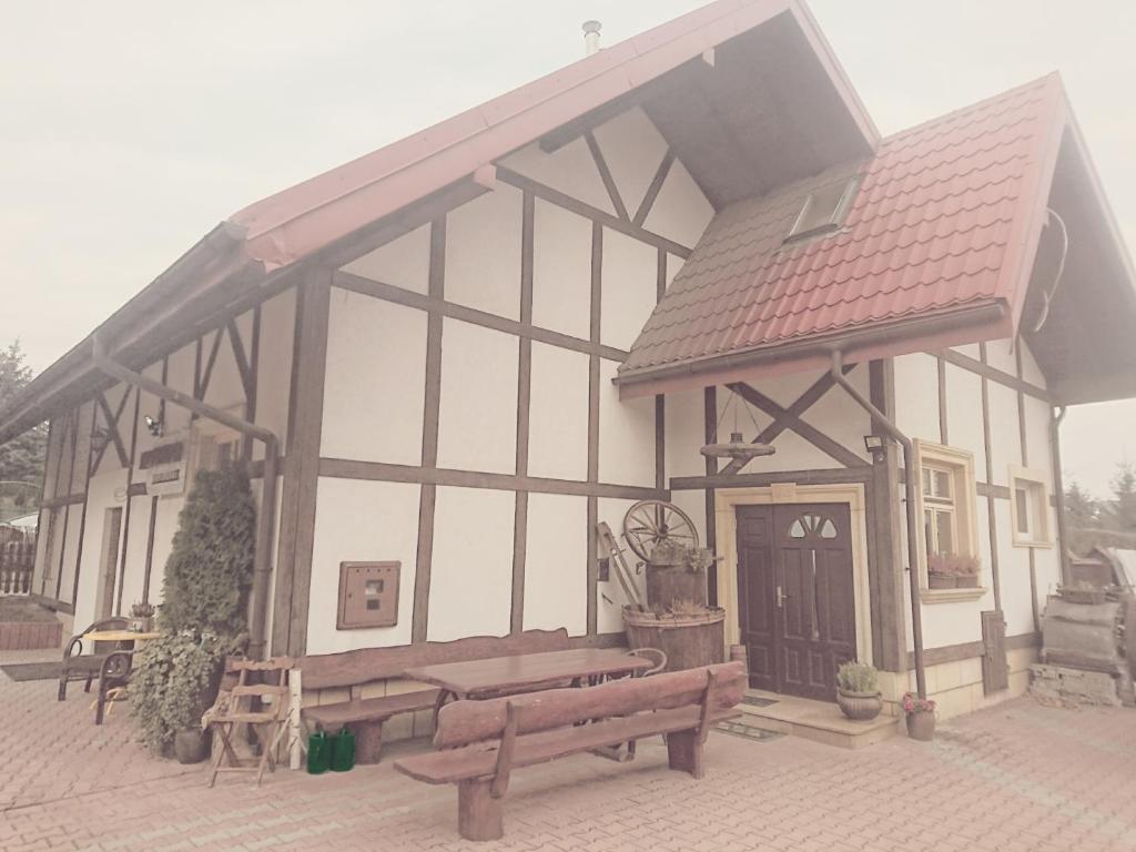 a building with two benches in front of it at NOCLEGI POD STODOŁĄ in Kraków