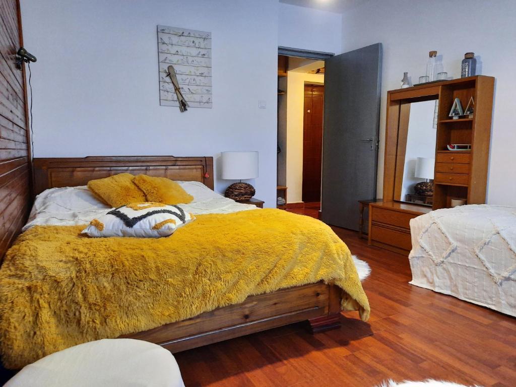 una camera da letto con un letto con una coperta gialla sopra di Cocooning in a Lovely Mountain suite - One ad Azuga