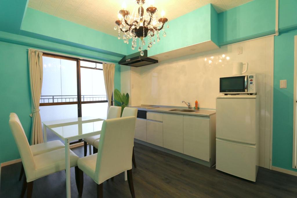 a kitchen with a table and chairs and a refrigerator at EG52 Elizabeth Garden in Osaka