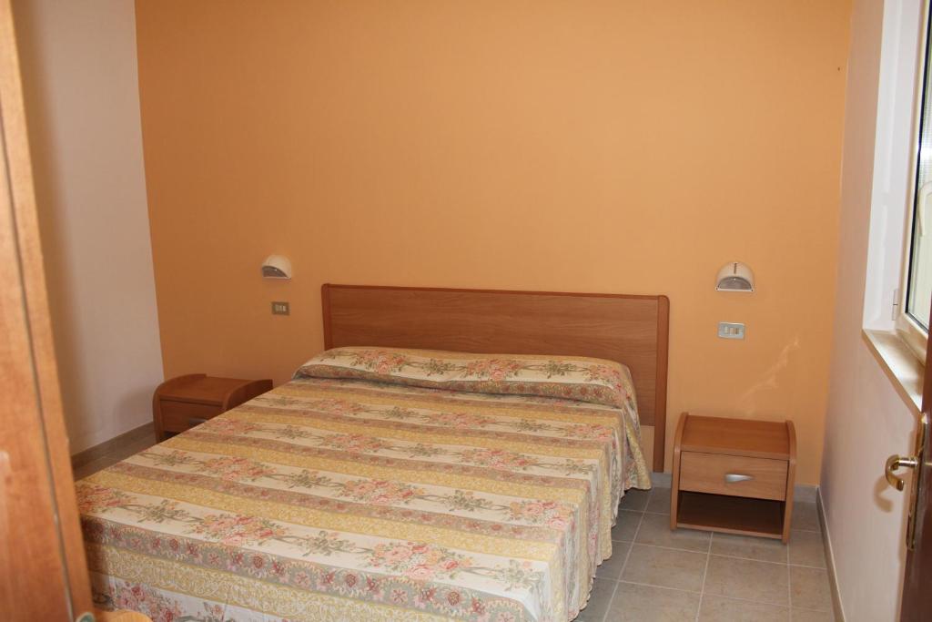 ヴィエステにあるResidence San Luca Viesteの小さなベッドルーム(ベッド1台、ナイトスタンド2台付)