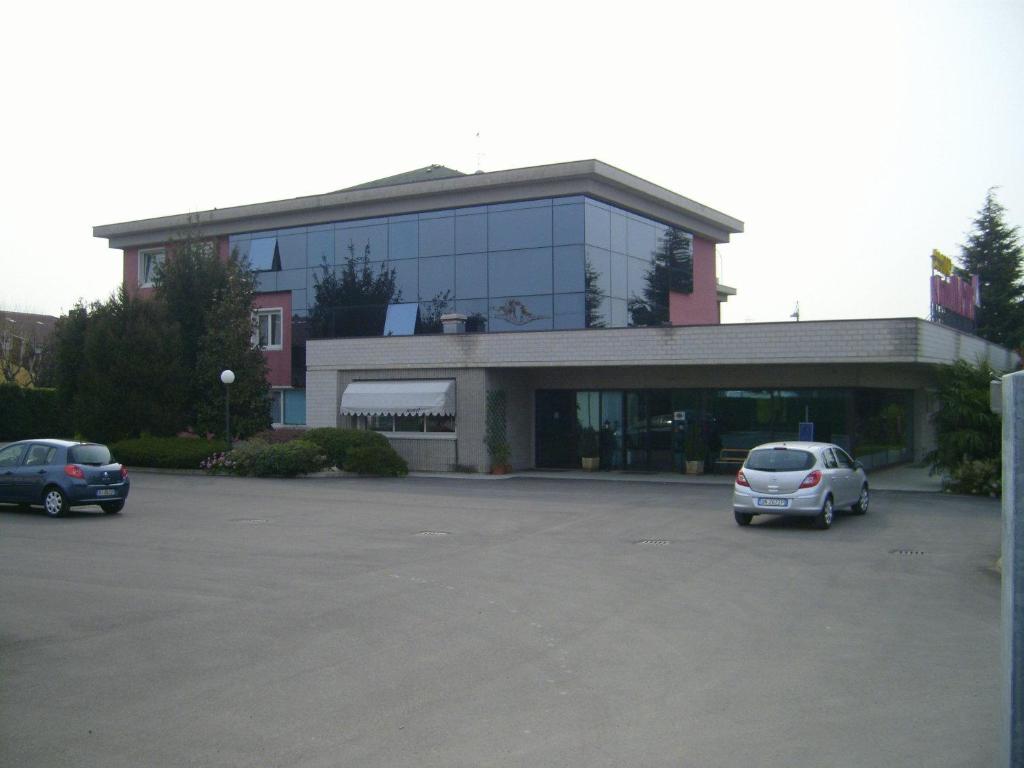 a building with two cars parked in a parking lot at Art & Hotel Treviolo in Treviolo