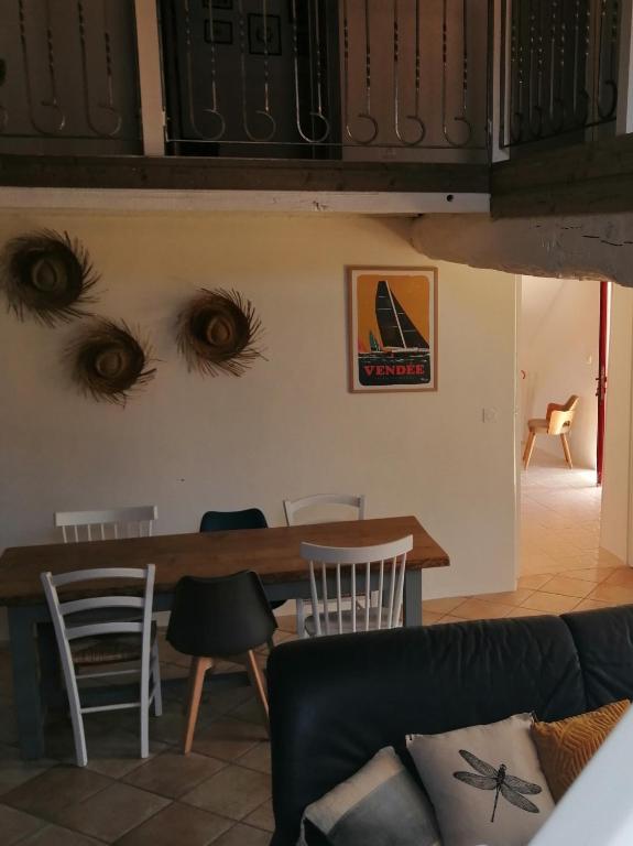 a living room with a table with eyes on the wall at Le cottage de l'étang in Le Tablier