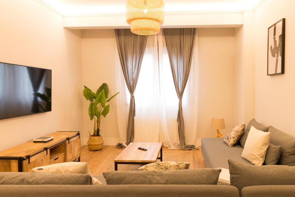 ein Wohnzimmer mit einem Sofa und einem Tisch in der Unterkunft Zabalburu in Bilbao