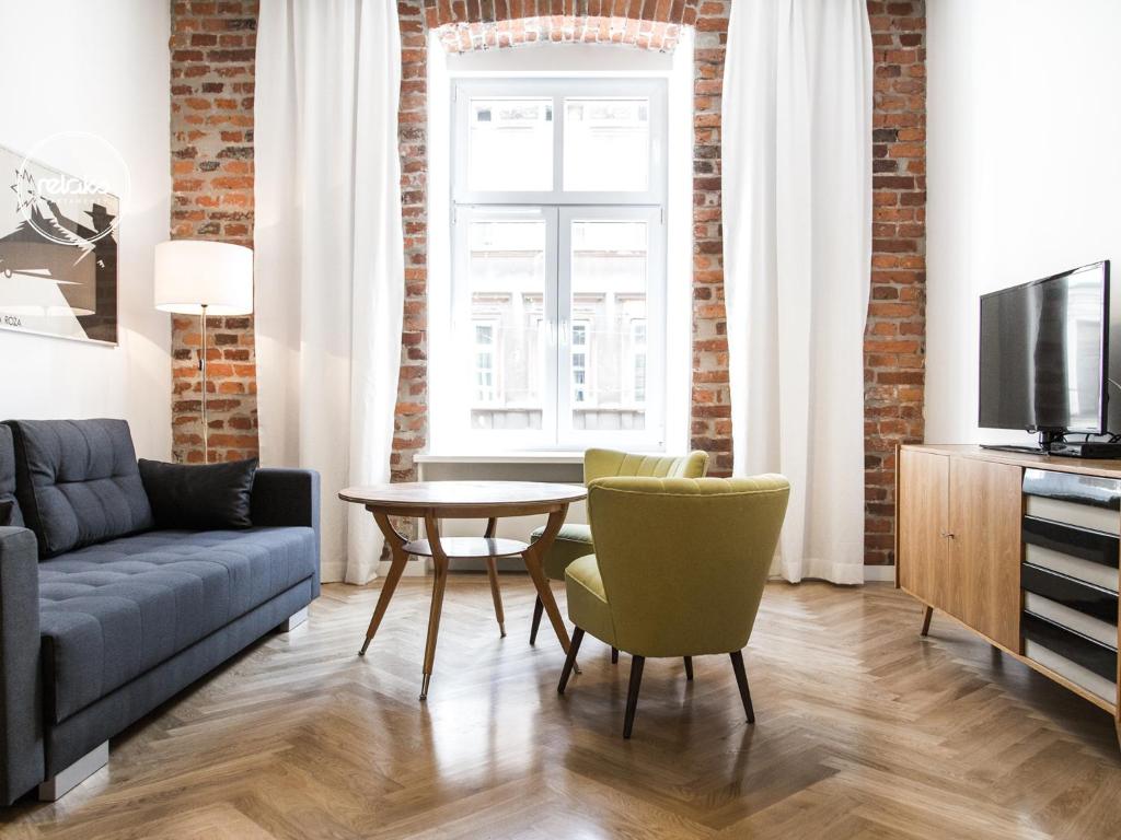 
a living room filled with furniture and a tv at Relaks Apartamenty in Kraków
