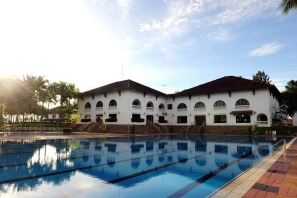 a large white building with a large swimming pool at Ponderosa Golf & Country Resort in Johor Bahru