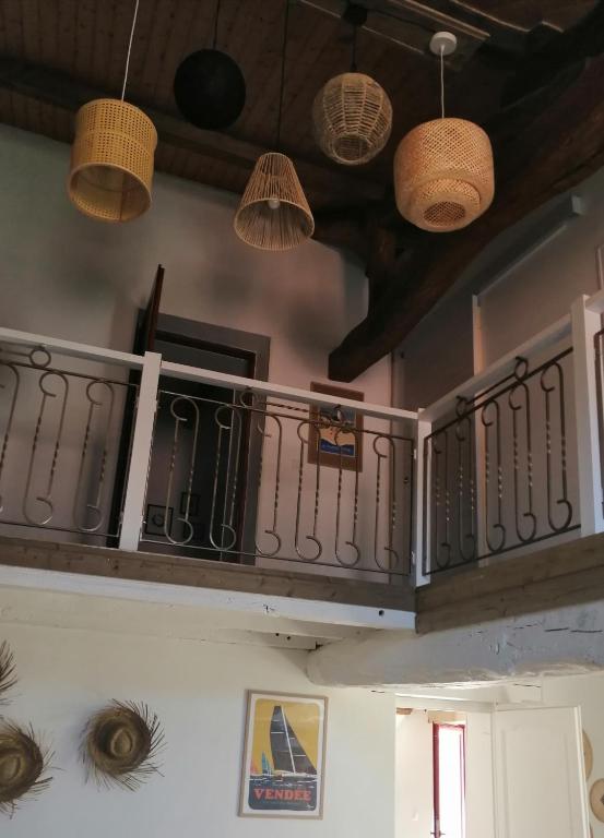 a room with a balcony with pendant lights at Le cottage de l&#39;étang in Le Tablier