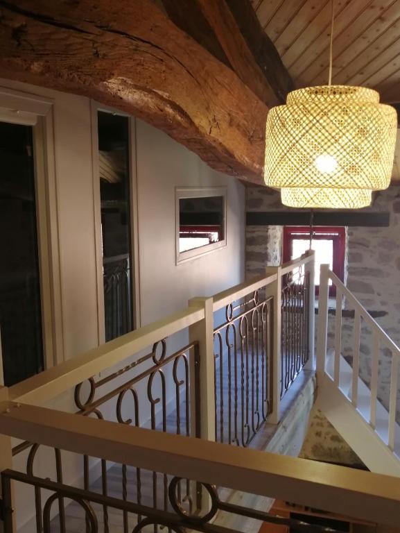 a staircase in a house with a chandelier at Le cottage de l&#39;étang in Le Tablier