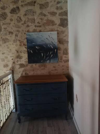 a blue dresser in a room with a painting on the wall at Le cottage de l&#39;étang in Le Tablier