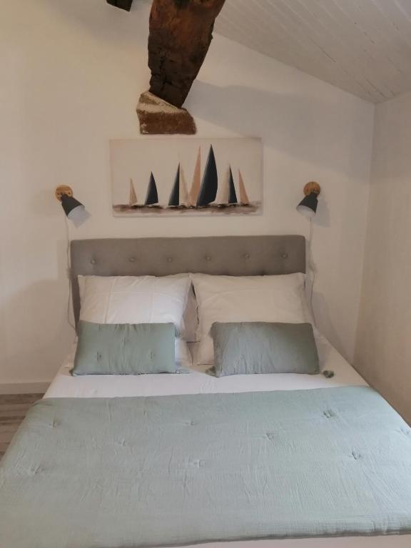 a bedroom with a bed with sails on the wall at Le cottage de l&#39;étang in Le Tablier
