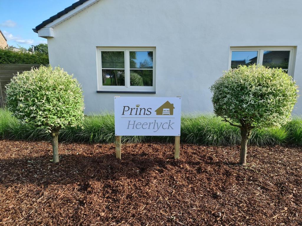 a sign in front of a house with two trees at Prinsheerlyck in As