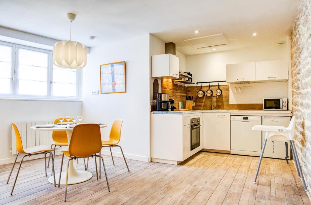 une cuisine et une salle à manger avec une table et des chaises dans l'établissement 350 m de la plage - Bel appartement pour 4, à Penmarcʼh
