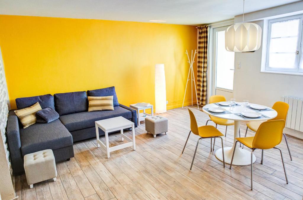 a living room with a couch and a table at Charmant appartement pour un sejour authentique au coeur du Finistere in Penmarch