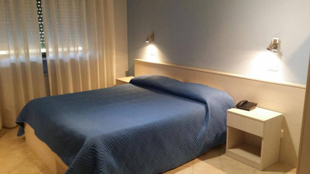 a bedroom with a blue bed and two lights at HOTEL SIRIO in Villa D'agri