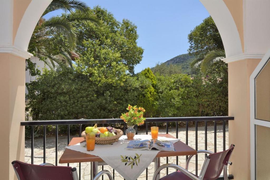 a table with a bowl of fruit on a balcony at Loukas Inn Family Resort in Keri