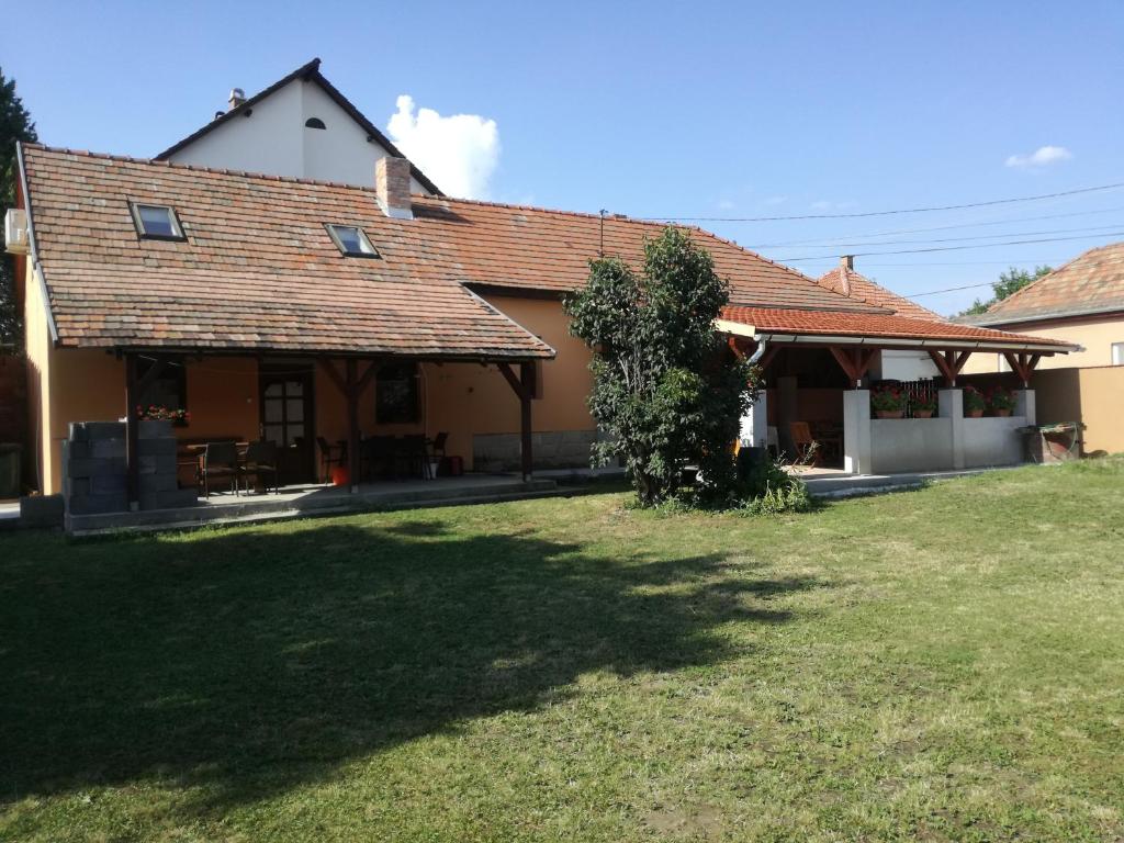 a house with a grass yard in front of it at Guliba Vendégház in Bogács