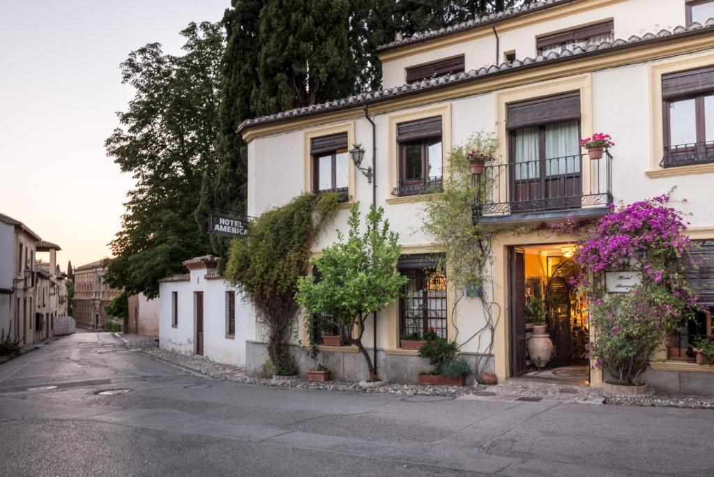 a building with flowers on the side of a street at Hotel América in Granada