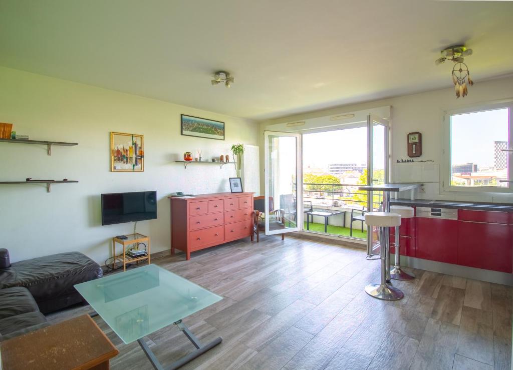 a living room with a couch and a table at Métro 12, Stade De France, Parking, Balcon, 45m2, View, in Aubervilliers