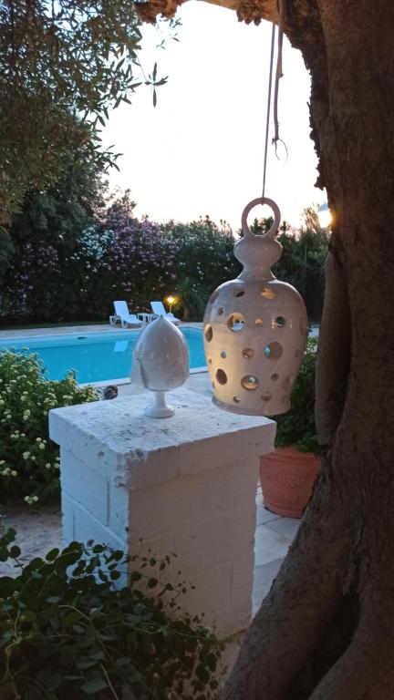 dos jarrones sentados en una pared junto a una piscina en Dimora Celeste, en Ostuni